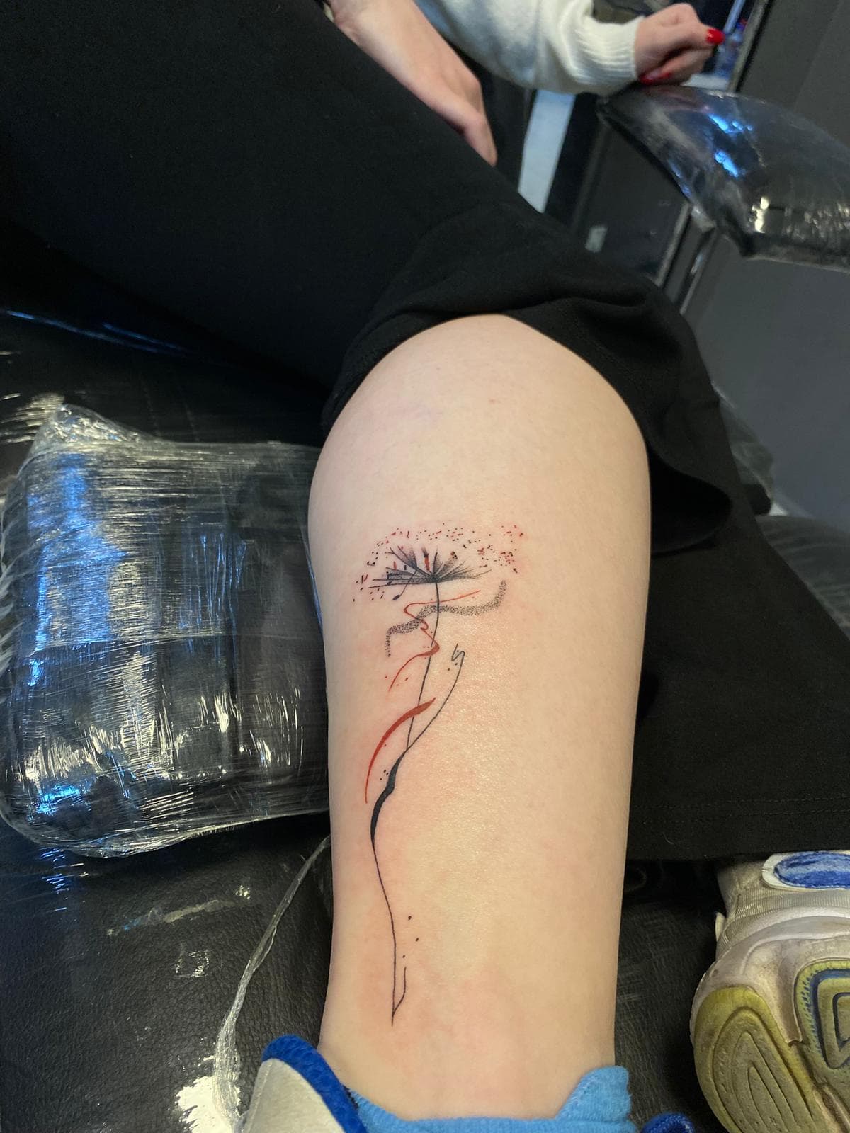 Baldırda kırmızı vurgulu ince çizgi karahindiba — Ersin Tattoo Bakırköy