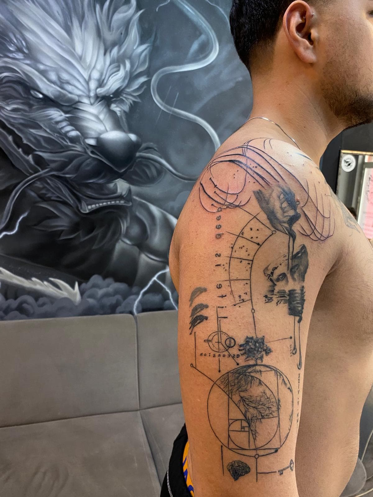 Üst kolda ince çizgi kutsal geometri: Fibonacci sarmalı ve heykel portresi — Ersin Tattoo Bakırköy
